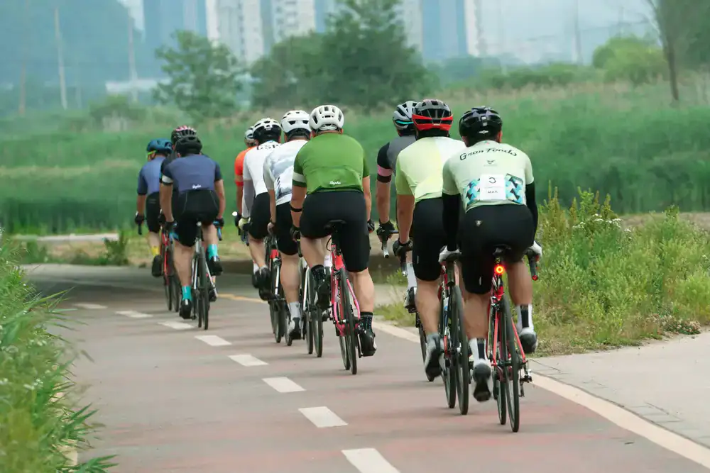 A group of cyclists riding together on a scenic paved path