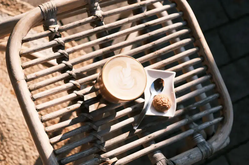 A restored bicycle parked next to a café table with a cup of specialty coffee