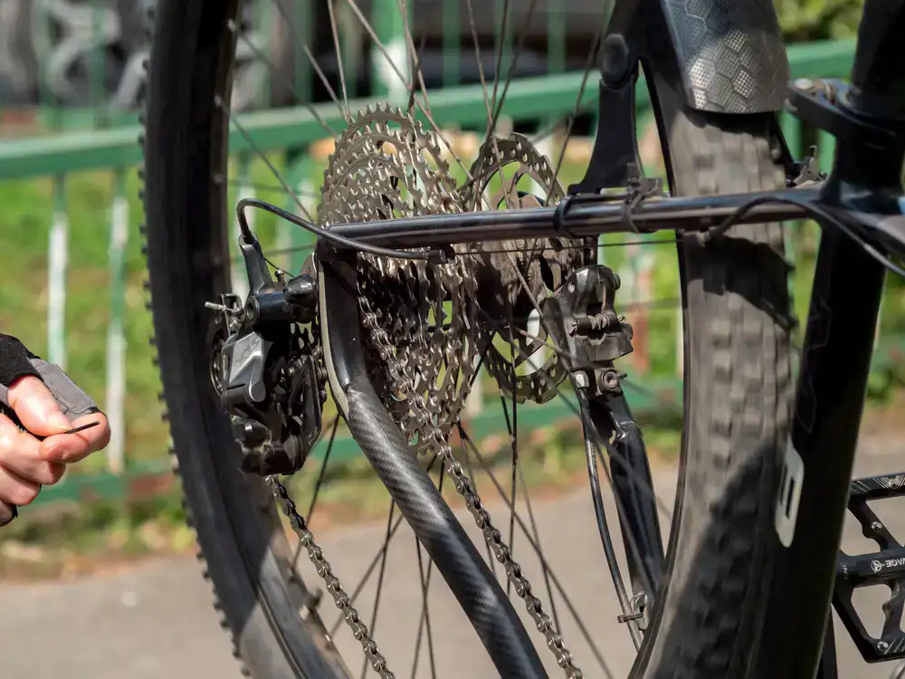 Mechanic carefully adjusting bicycle gears in a bright, organized workshop